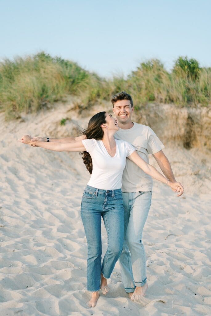 couple wearing jeans and t-shirts on the beach in watch hill, ri