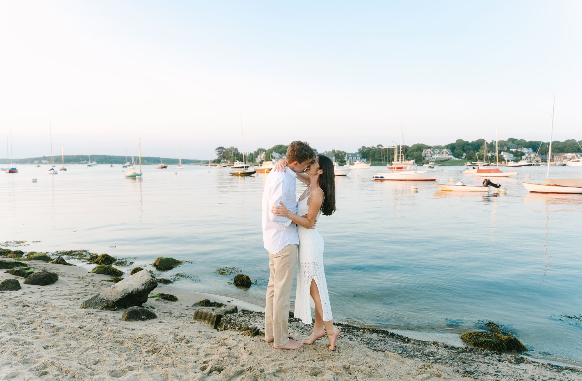 couple on the beach wearing white dress and white shirt with tan pants